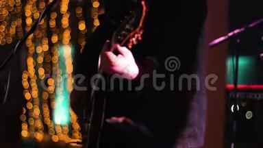 在<strong>夜店</strong>的深夜演出中，音乐家在舞台上弹吉他的镜头被裁剪。 中弹。